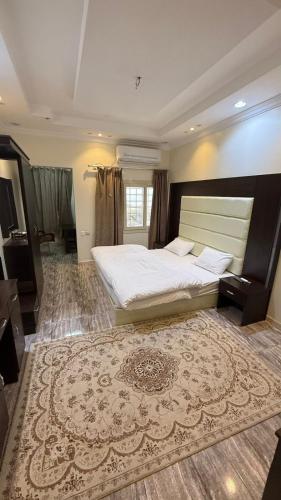 a bedroom with a large bed and a large rug at نزل الصيف للشقق المخدومة in Al Namas