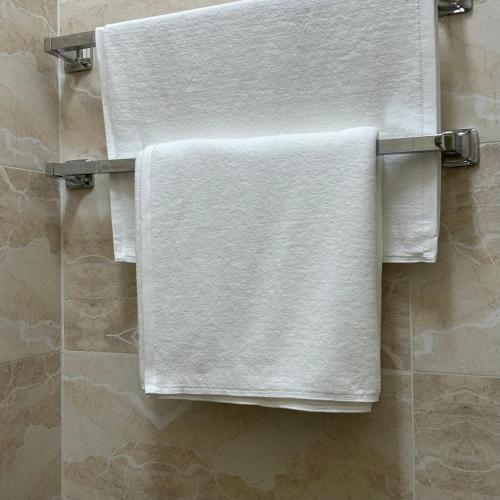 a group of towels hanging on a towel rack in a bathroom at نزل الصيف للشقق المخدومة in Al Namas