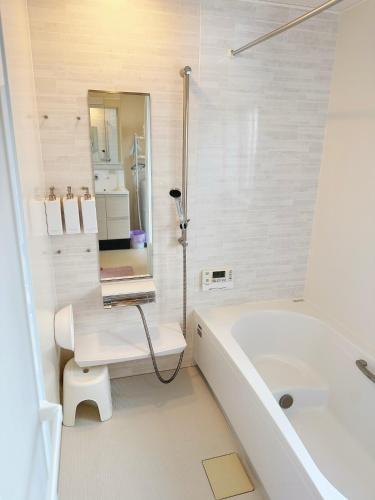 a bathroom with a bath tub and a laptop on a table at Solf潮崎 in Itoman
