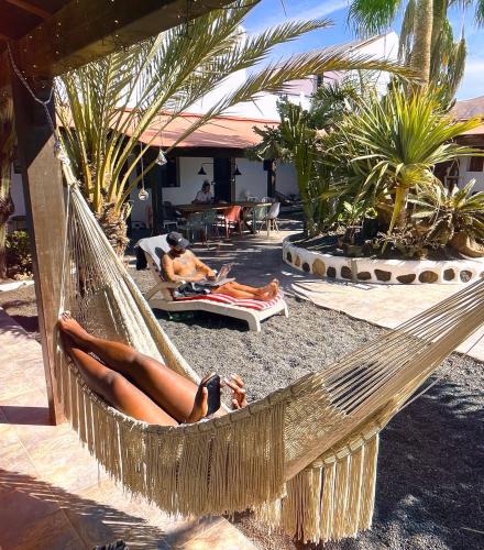 a woman laying in a hammock on a beach at Casa Cocolores in Villaverde
