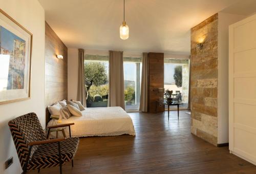 a bedroom with a bed and a stone wall at BRIGHTLINE VILLA 8, Emma Villas in Asproli