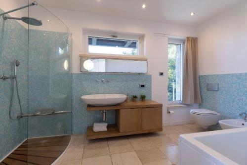 a bathroom with a sink and a shower and a toilet at BRIGHTLINE VILLA 8, Emma Villas in Asproli