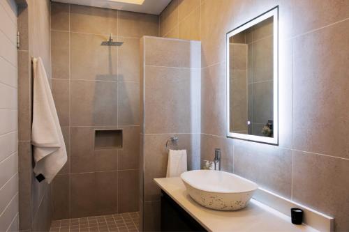 a bathroom with a sink and a shower with a mirror at 3BR Drakensberg Retreat, Mountain Views and Braai in Ardmore
