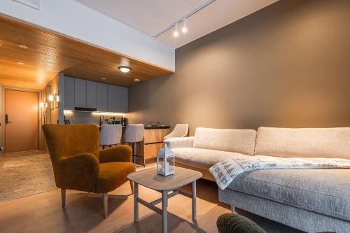 a living room with a couch and chairs and a kitchen at Utsun Gielas A5 Visit Levi in Levi