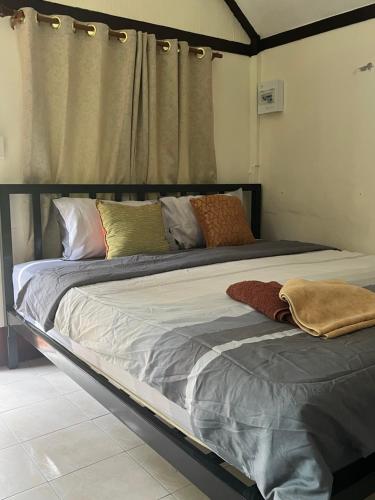 Una cama grande con almohadas en un dormitorio. en Mayow Bungalow Kohmook Trang, en Trang