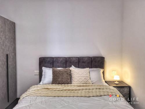 a bedroom with a large bed with a gray headboard at R&F Princess Cove Double Bed Room Shared Common Space in Johor Bahru