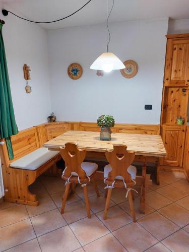 een eetkamer met een houten tafel en stoelen bij Lo chalet di Lucky in Campodolcino
