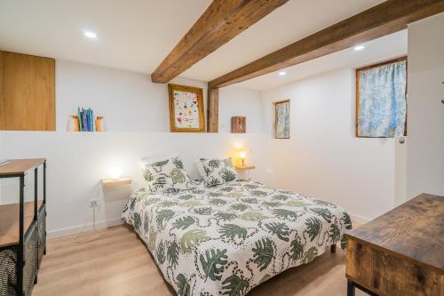 Un dormitorio con una cama con un edredón verde y blanco. en Au Stammtisch - Cozy, rustic and authentic, en Scherwiller