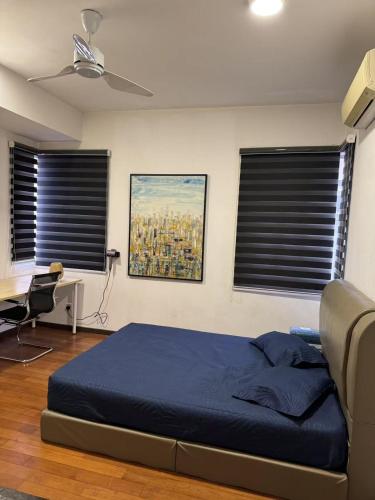 a bedroom with a bed and a desk and two windows at JM House Kuala Lumpur in Puchong