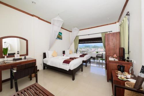 a hotel room with two beds and a mirror at Luang Prabang View Hotel in Luang Prabang