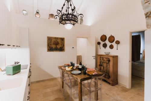 a kitchen with a table and a chandelier at Trulli Ad Maiora in Alberobello