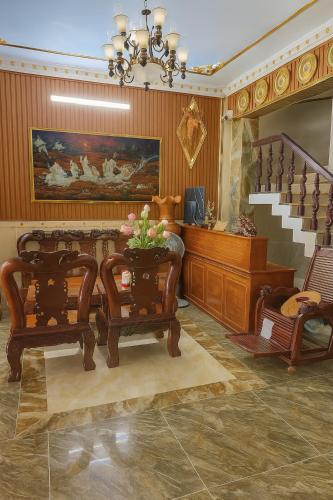 a room with chairs and a staircase with a painting at Hostel Luxury Sài Gòn in Rạch Giá