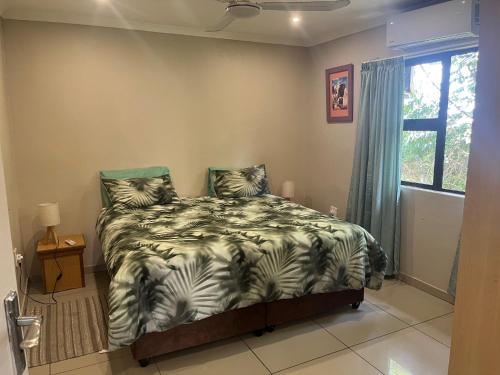 a bedroom with a bed with a zebra blanket at Ingwenya Chalet in Sodwana Bay