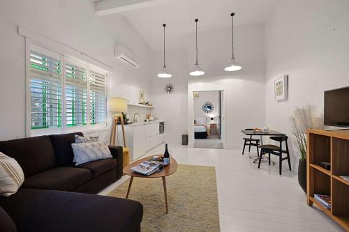 a living room with a couch and a table at Apartment 22 - stylish retreat in central location in Fitzroy
