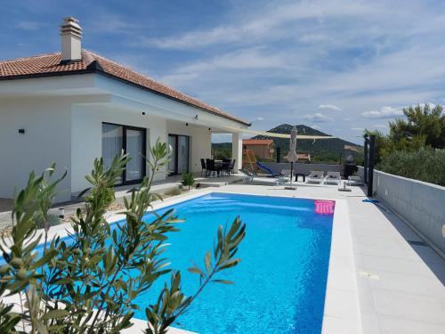 ein Swimmingpool vor einer Villa in der Unterkunft Holiday house Miki in Kakma