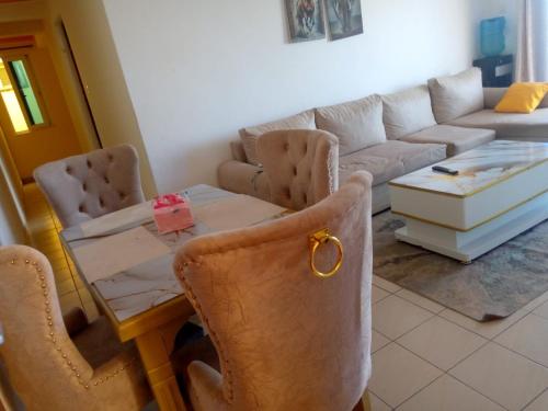 Mtwapa home stay Apartment في مومباسا: غرفة معيشة بها طاولة وأريكة