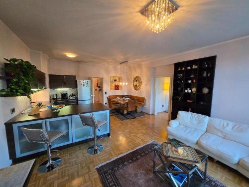 ザンクト・ファイト・アン・デア・グランにあるExklusive Penthousewohnung im Stadtzentrumの白いソファとキッチンのあるリビングルーム