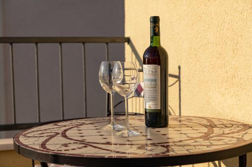 een fles wijn en twee wijnglazen op een tafel bij Apartments Kristić in Dubrovnik