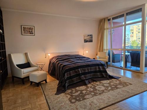 ザンクト・ファイト・アン・デア・グランにあるExklusive Penthousewohnung im Stadtzentrumのベッドと椅子と窓のある寝室