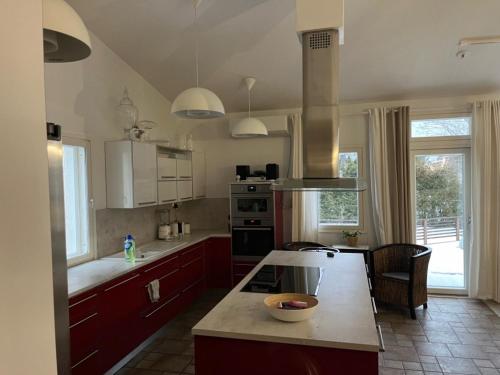 eine Küche mit roten Schränken und einer Arbeitsplatte in der Unterkunft Wonderful townhouse 214 m2 close to outdoor areas in Helsinki