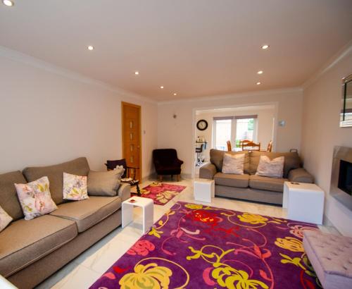 a living room with two couches and a rug at Smitten House 4 Bedroom RHYL in Rhyl