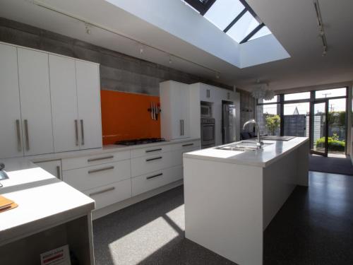 a large kitchen with white cabinets and a skylight at Fabulous In Fitzroy - seconds to Fitzroy Beach in New Plymouth
