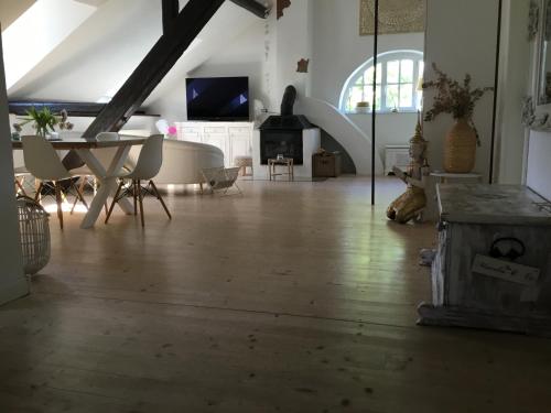 a living room with a table and a fireplace at Historisches Designer Loft Nähe Waldorfer Höfe in Ochtendung