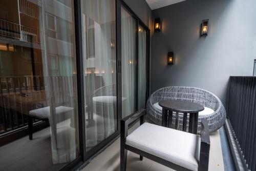 ナ・ジョムティエンにあるBayphere Residence by Prop Hopperのバルコニー(テーブル、椅子付)、窓が備わります。