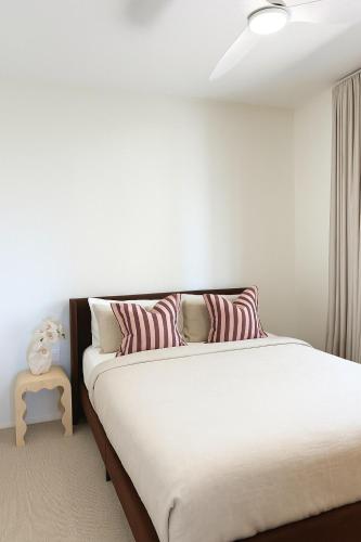 アレクサンドラ・ヘッドランドにあるBeachfront Penthouse With Uninterrupted Ocean Viewsのベッドルーム1室(赤と白の枕が備わるベッド1台付)