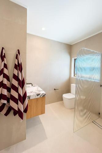 アレクサンドラ・ヘッドランドにあるBeachfront Penthouse With Uninterrupted Ocean Viewsのシャワー、洗面台、トイレ付きのバスルーム