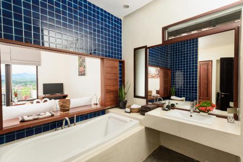 a bathroom with a tub and a large mirror at Luang Prabang View Hotel in Luang Prabang