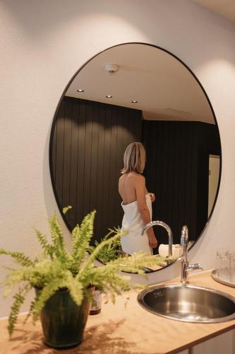 a woman is standing in front of a mirror at Haus Braunarl in Lech am Arlberg