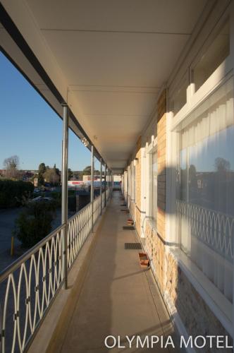 a hallway of an office building with a sidewalk at Olympia Motel in Queanbeyan