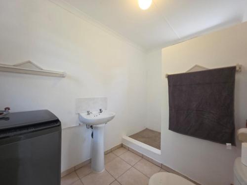 un bagno bianco con lavandino e WC di Caboodle a Kenton-on-Sea