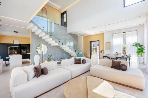 Una sala de estar con muebles blancos y una escalera. en Luxury Villa, Design, Comfort, Heated Pool, Games, en Marrakech