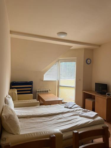 a room with a bed and a table and a window at PM Services Royal Plaza Apartments in Borovets