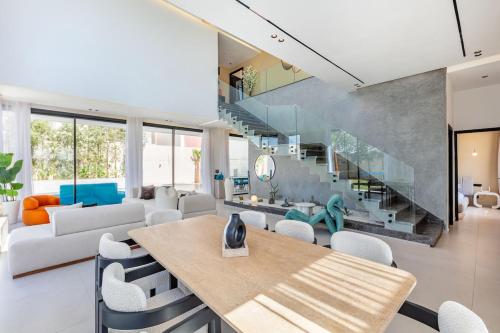 a living room with a table and chairs and a staircase at Luxury Villa, Design, Comfort, Heated Pool, Games in Marrakech