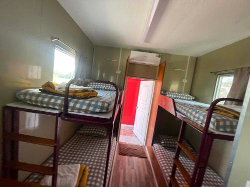 a small room with three bunk beds in it at SriHOME in Ban Don Tum (1)