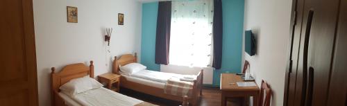 a room with two beds and a window at Pensiunea Muresul in Târgu-Mureş