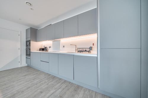 CBGにあるPeaceful and stylish apartment near Cambridge with parkingの白いキャビネットとダイニングエリア付きのオープンキッチンが備わります。