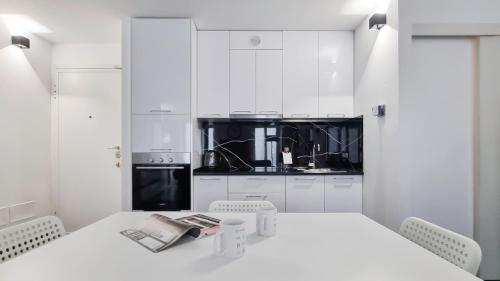 a kitchen with white cabinets and a white table at Italianway - Torino 57 A in Milan