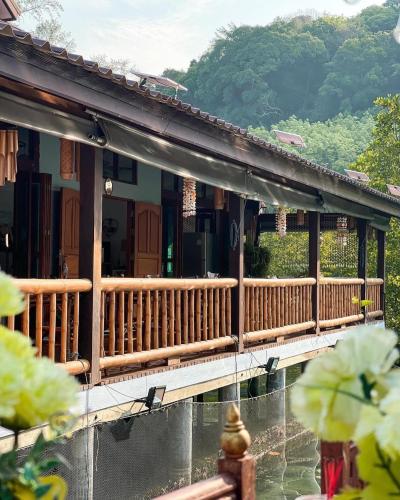 a house with a wooden deck with a mountain in the background at À La Koh Kood Resort in Ko Kood