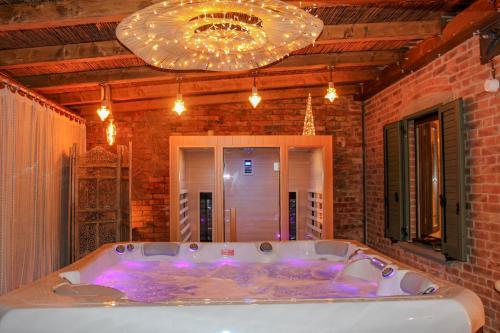een groot bad in een kamer met een bakstenen muur bij Holiday Home Croce with Spa in La Croce