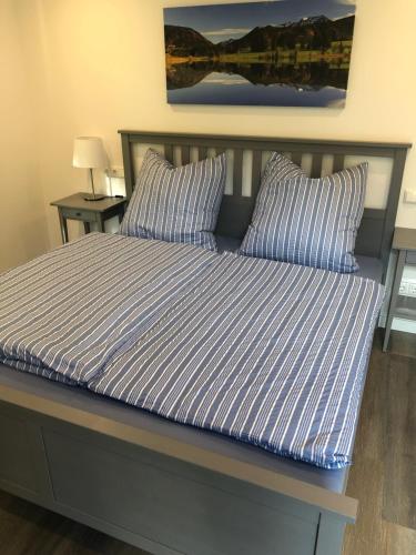 een bed met blauwe en witte gestreepte lakens en kussens bij Ferienchalet Flößwehrtal in Bad Lauterberg