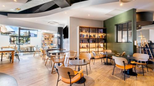 a restaurant with tables and chairs in a room at Campanile PRIME - Nice Airport in Nice