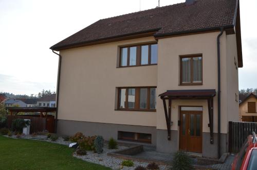 una casa blanca con techo marrón en Ubytování u zastávky, en Modrá