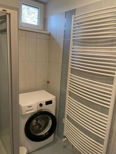 uma máquina de lavar roupa na casa de banho com uma janela em Ubytování u zastávky em Modrá
