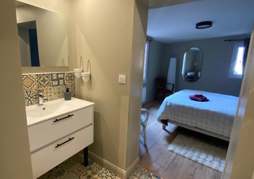 La Lucienne - Cœur de ville avec un extérieur في مونتروي-سور-مير: حمام مع حوض وسرير مع مرآة