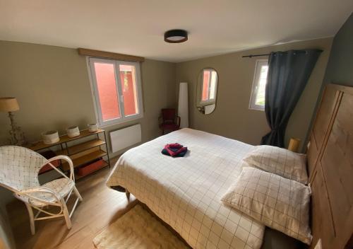 La Lucienne - Cœur de ville avec un extérieur في مونتروي-سور-مير: غرفة نوم بها سرير وكرسي ونوافذ