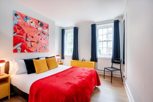 a bedroom with a large bed with a red blanket at Welcome London Theatreland House in London
